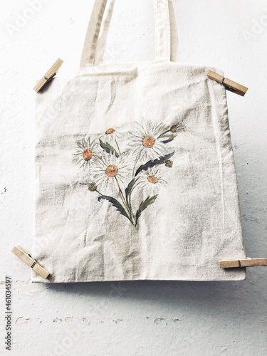 Freshly painted tote bag with a daisy flower pattern drying photo
