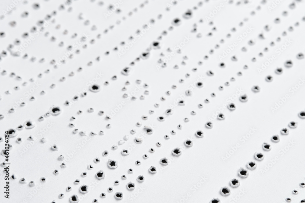 Fototapeta premium Perforated pattern on surface of paper. Close-up texture