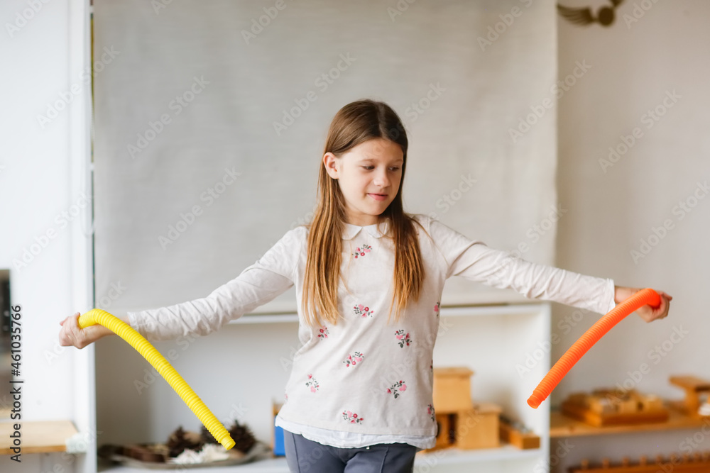 Cute Caucasian Long Hair Preteen Kid Girl Playing With Two Pop Tubes Fashion Fidget Finger Toys Mini Tubes Stretch Pull Tube Light Real Interior Cute Caucasian Long Hair Preteen Kid Girl Playing With Two Pop Tubes Fashion Fidget Finger Toys Mini Tubes Stretch Pull Tube Light Real Interior