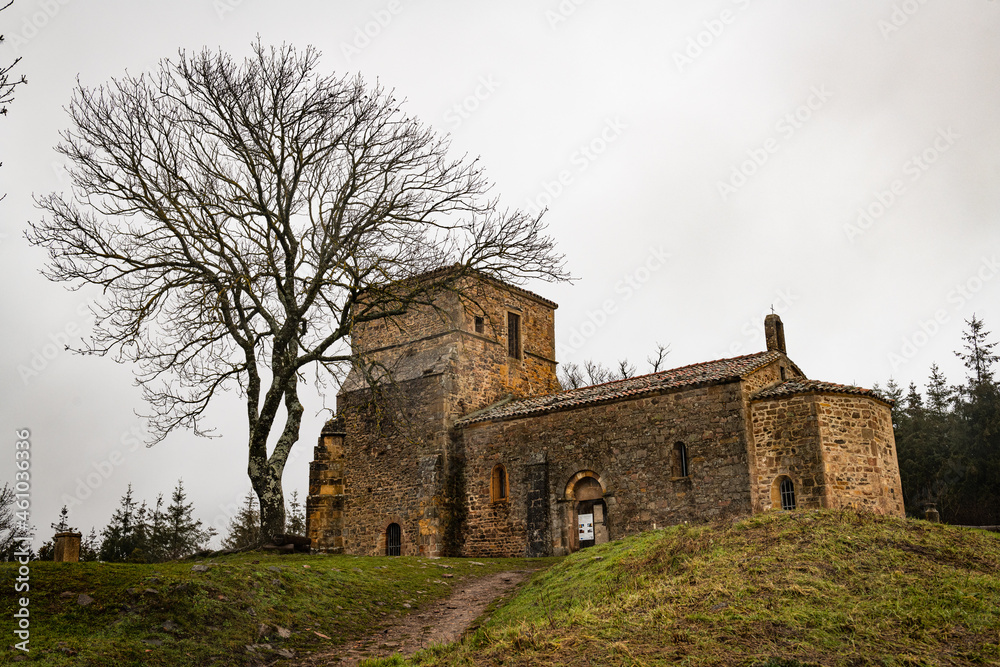 Paysage d'une chapelle au sommet d'une colline à coté d'un arbre sans feuilles