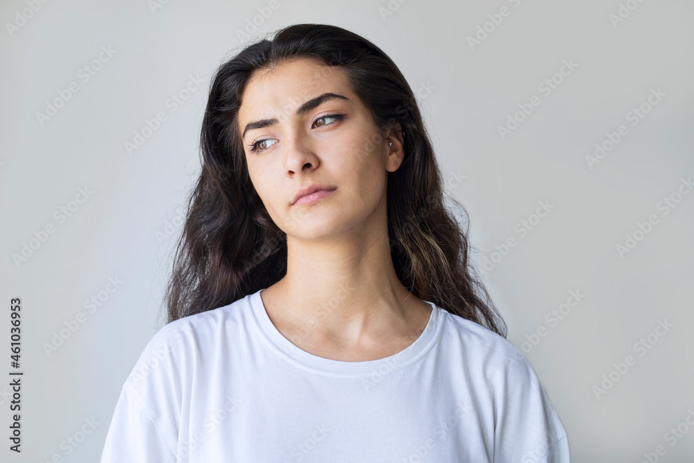 young woman with a serious look on her face - gray background with copy space young woman with a serious look on her face - gray background with copy space