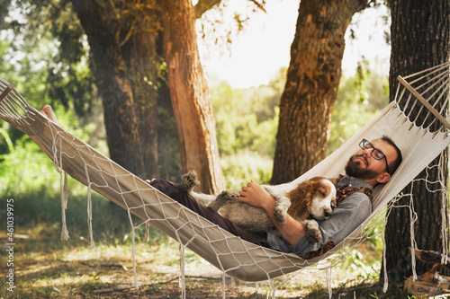 Slika na platnu Person sleeping with his dog in a hammock in beautiful summer scene
