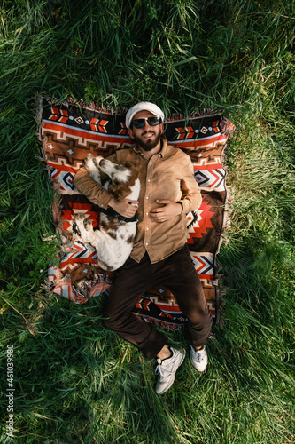 Overhead view of a man and dog resting on the green grass in the summer