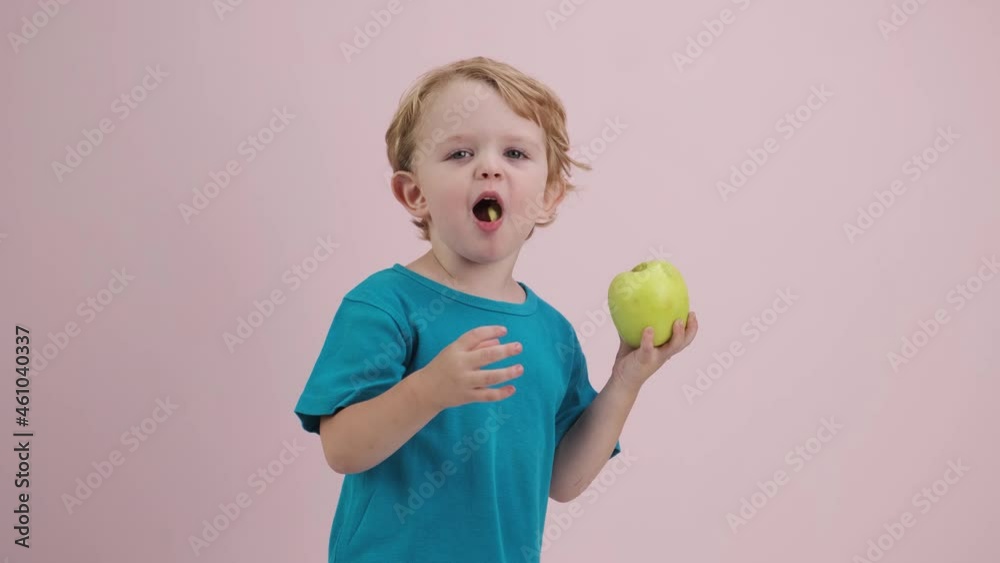 Cute Child on Pink Background of Holding a Green Apple and Choice Healthy Eating. Cute Child on Pink Background of Holding a Green Apple and Choice Healthy Eating.