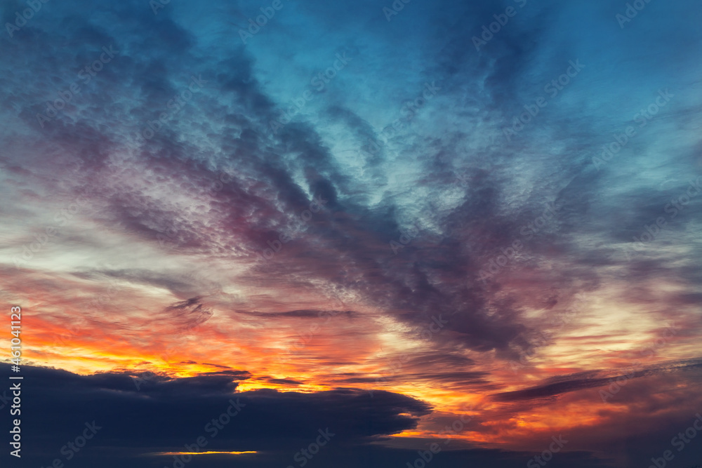 Dramatic colorful red orange to dark blue sunset or sunrise sky landscape clouds. Natural beautiful cloudscape dawn background wallpaper. Stormy windy nature twilight dusk scene panorama
