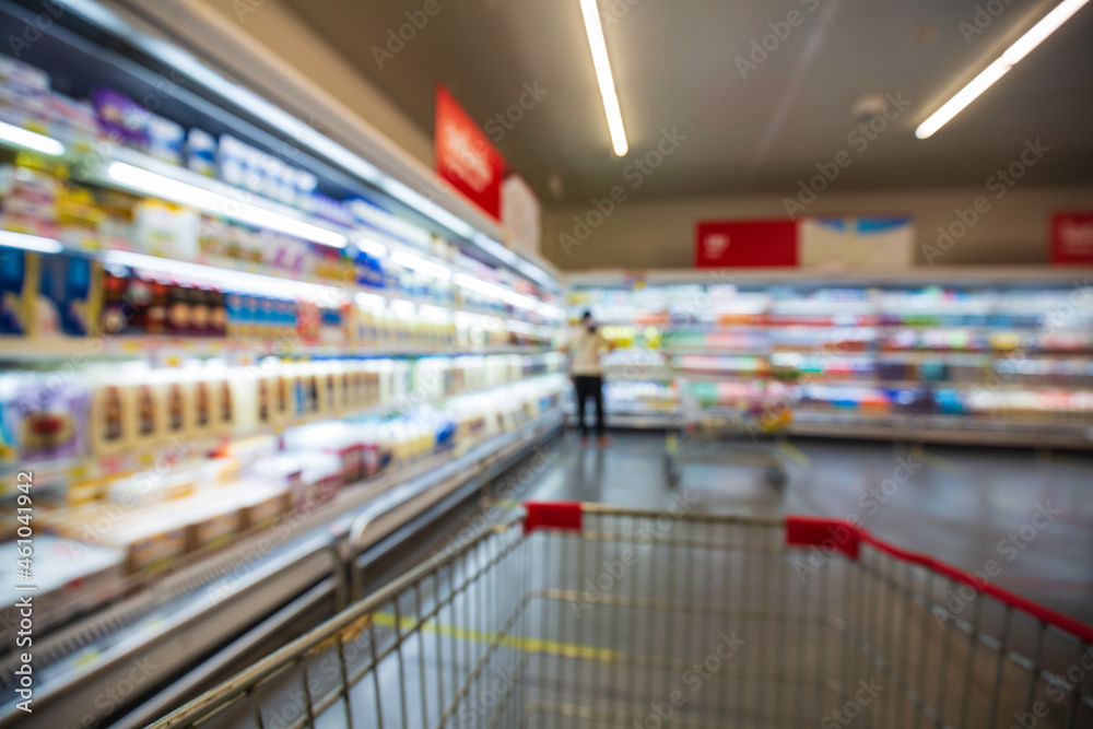 The defocused blur of female drink milk food buying cart shopping put on a shelf at the drink.