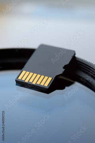 micro sd card for use in photo and video technology. micro sd lies on the lens filter. close-up.