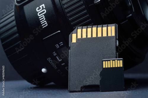 micro sd card with adapter on the background of a replaceable lens for a digital camera.