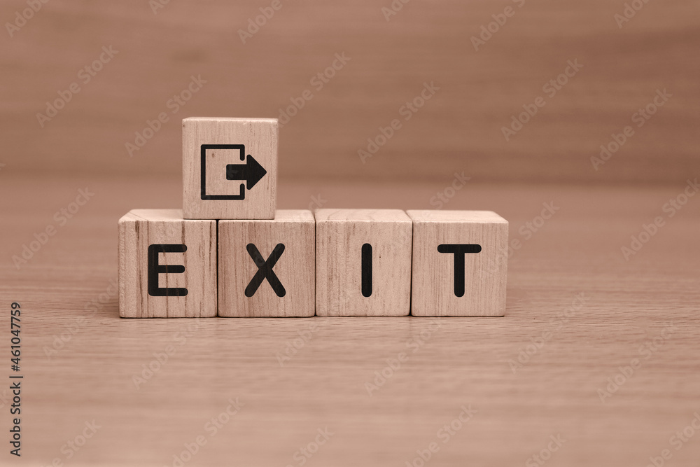 wooden cube with text EXIT on a wooden table wooden cube with text EXIT on a wooden table