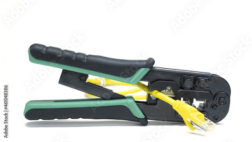 Modular plug crimper for RJ-45 on white background. Crimping tool with connectors on isolated background with yellow patch cord. Clamp head tool LAN RJ45. Internet line cables and crimper.