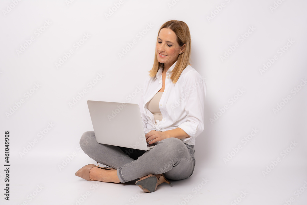 Business concept. Portrait of happy woman in casual clothing sitting on floor in lotus pose and holding laptop isolated over white background. Business concept. Portrait of happy woman in casual clothing sitting on floor in lotus pose and holding laptop isolated over white background.
