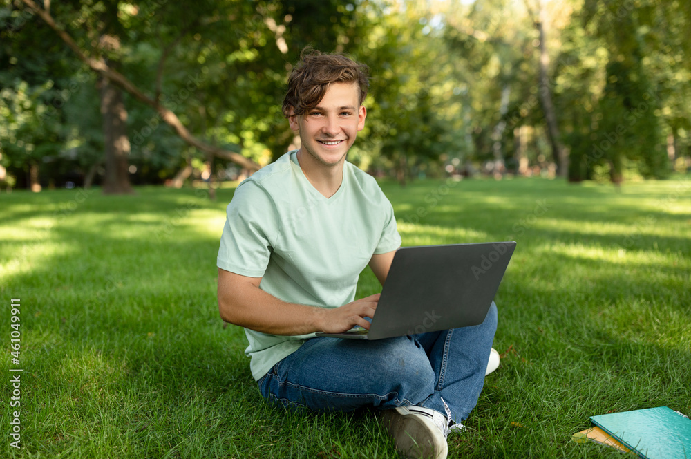Remote education concept. Happy student with laptop computer and books taking part in online class at park Remote education concept. Happy student with laptop computer and books taking part in online class at park