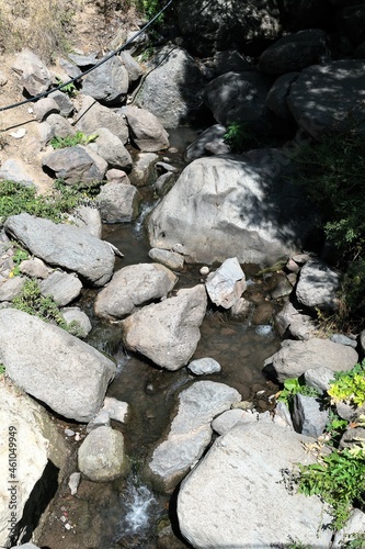 Mountain stream with large boulders as part of the landscape.