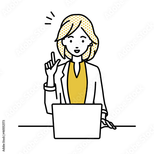 デスクで座ってPCを開いて何かひらめいたジャケットの女性