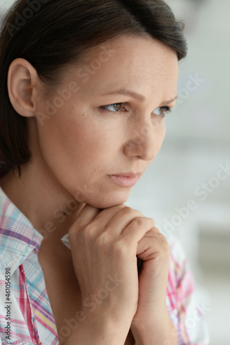Portrait of cute sad young woman posing at home