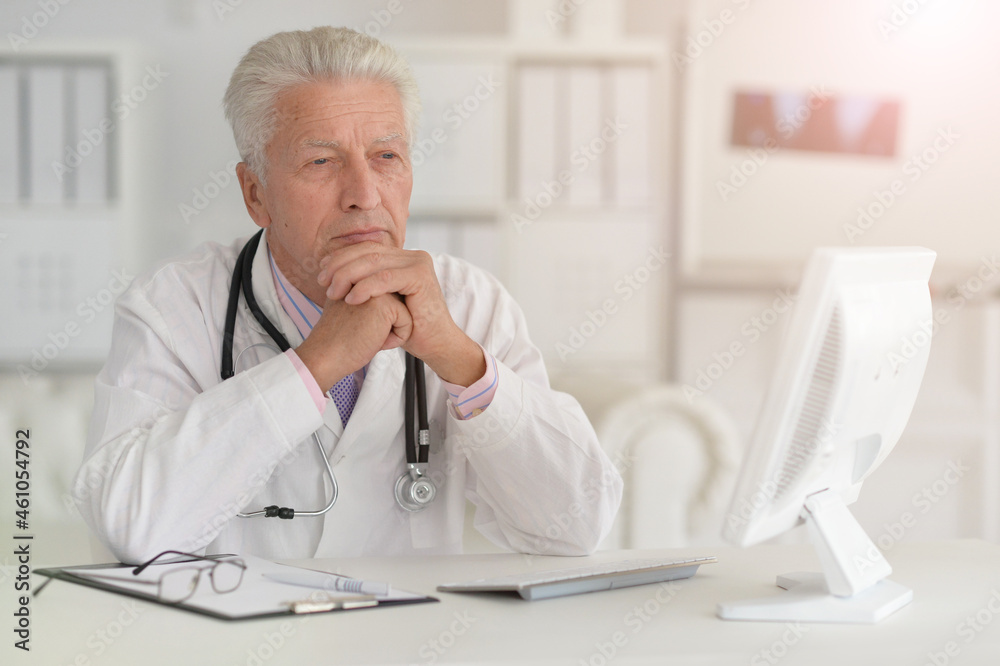 Portrait of senior male doctor working with laptop Portrait of senior male doctor working with laptop