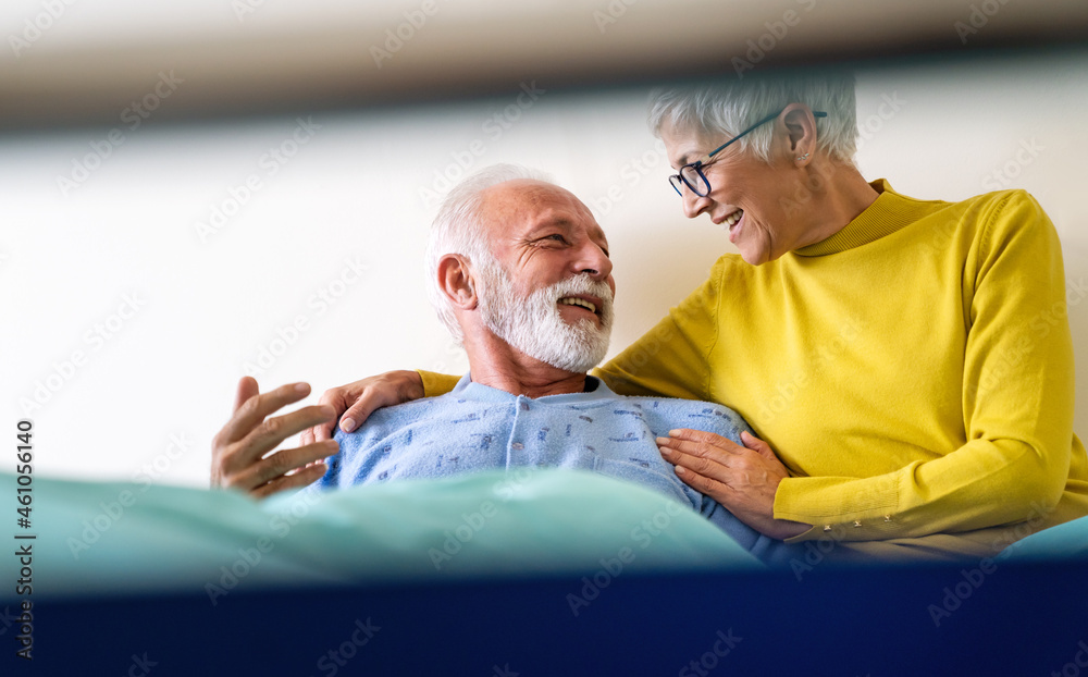 Obraz premium Mature couple in love. Happy senior woman visiting her husband in hospital ward.