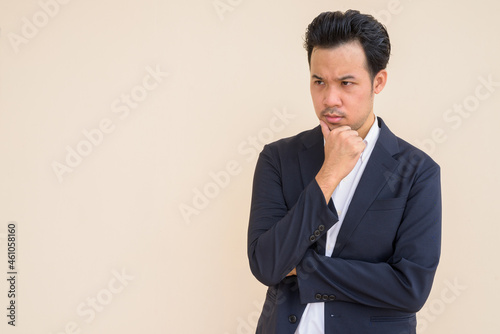 Serious Asian businessman thinking with hand on chin