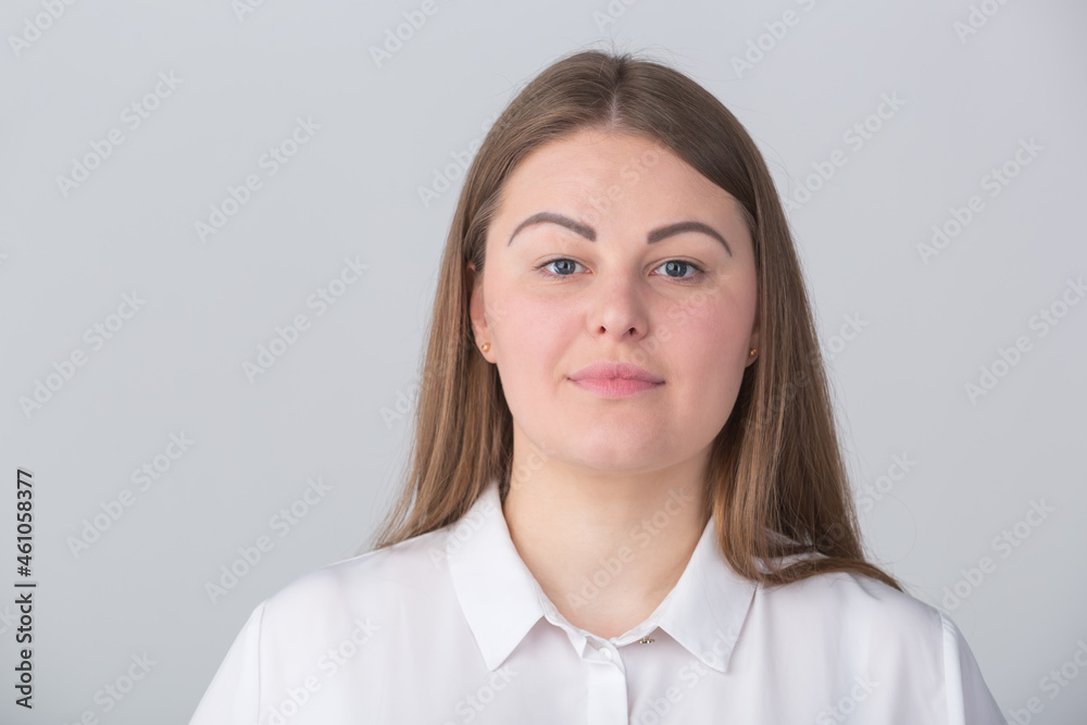 Studio portrait of overweight young woman in 30s wearing formal white shirt. Studio portrait of overweight young woman in 30s wearing formal white shirt.