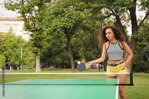 Young African-American woman playing ping pong outdoors