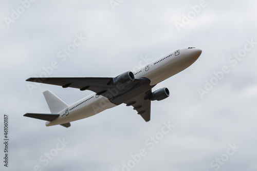 The concept of the trip is the take-off of a white plane. A model of a white airplane takes off into the sky  side view from below. Flight to 2022. Flight home. Departure on vacation.