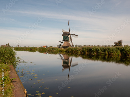 Historic mill along river in Dutch landscape, water reflections