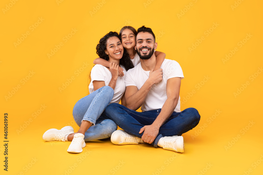 Arabic Parents And Little Daughter Hugging Posing On Yellow Background Arabic Parents And Little Daughter Hugging Posing On Yellow Background