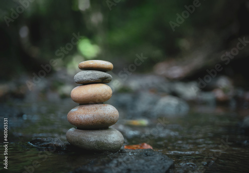 Stack of zen stones, Close up of pebble rocks stacked on top of each other in stream leading to a waterfall in a forest, Zen like concepts