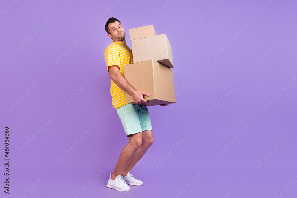 Full length body size photo man keeping heavy boxes delivery isolated pastel violet color background