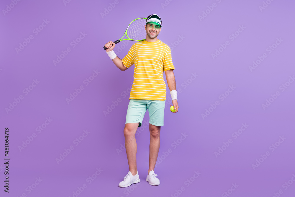 Full length body size photo man keeping tennis racket ball smiling isolated pastel violet color background Full length body size photo man keeping tennis racket ball smiling isolated pastel violet color background