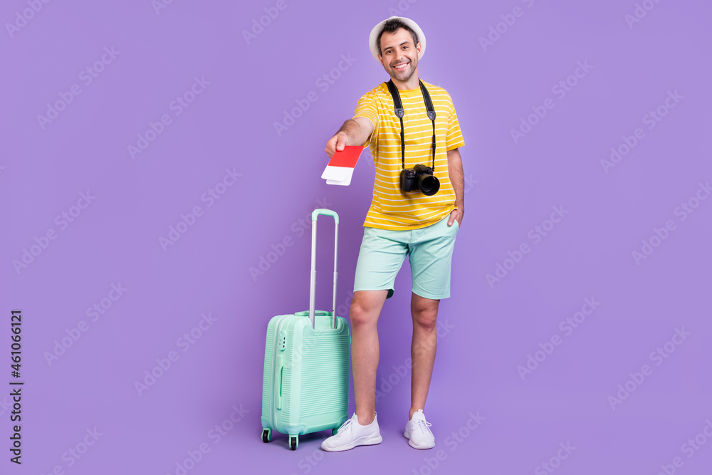 Full size photo of young man happy positive smile give documents registration check-in isolated over violet color background Full size photo of young man happy positive smile give documents registration check-in isolated over violet color background