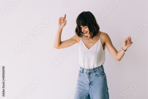 Portrait of a happy young woman dancing on white background