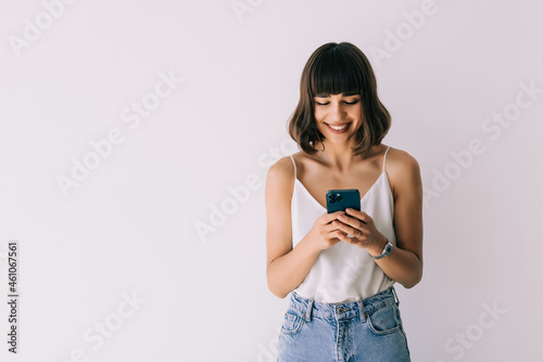 Young Woman wearing using a mobile phone isolated on a white background