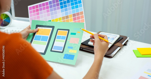 The designer sketches the layout and color of a mobile application.