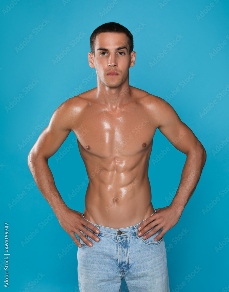 Fototapeta premium Handsome shirtless man with slim body on light blue background
