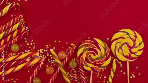 Colorful candies on a red background. Lollipop. Top view. Copy space.