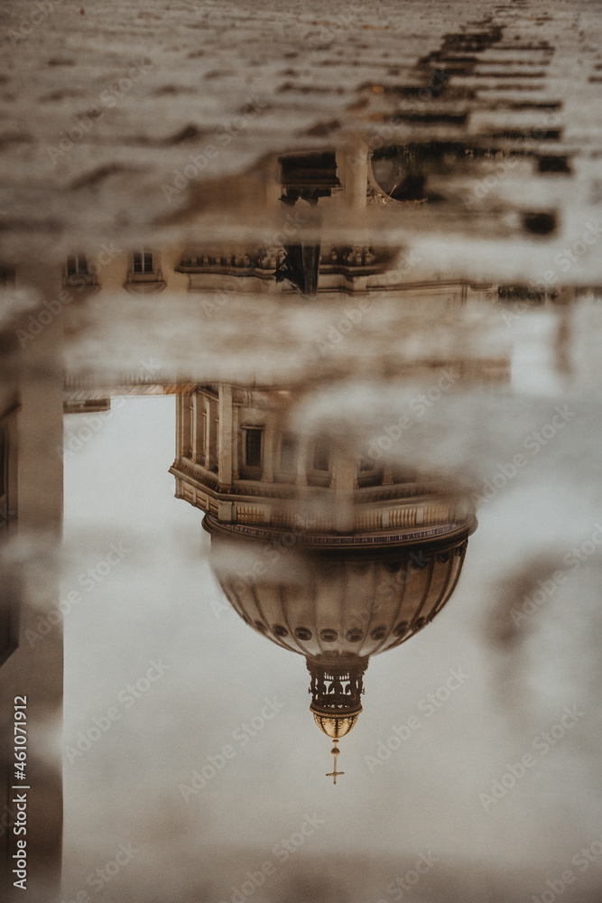 Reflection of a building in the puddle of the street with moody autumn atmosphere