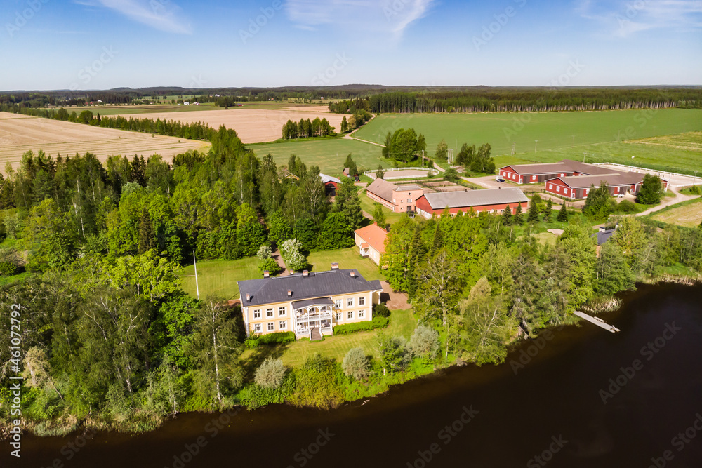 Kouvola, Finland - June 3, 2021: Aerial view of beautiful wooden Rabbelugn Manor - Takamaan Kartano. River Kymijoki bank.