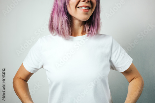Pretty plus size model with white blank t-shirt and pink hear, empty grunge wall background. Happy no face portrait