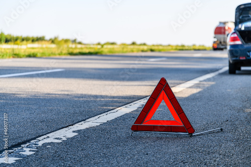Broken car at the roadside. Red warning triangle at foreground © ihorbondarenko