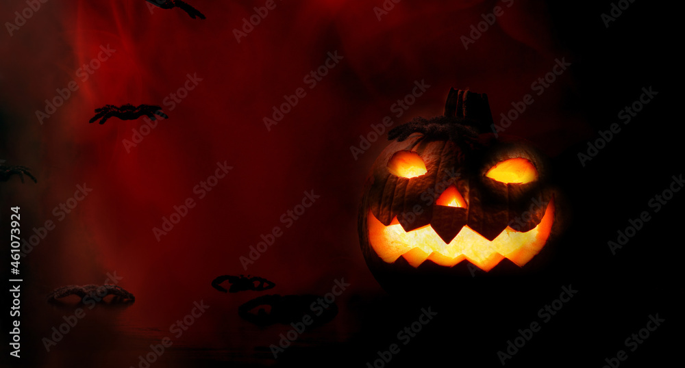 Halloween pumpkin with spiders and hellish dark red background