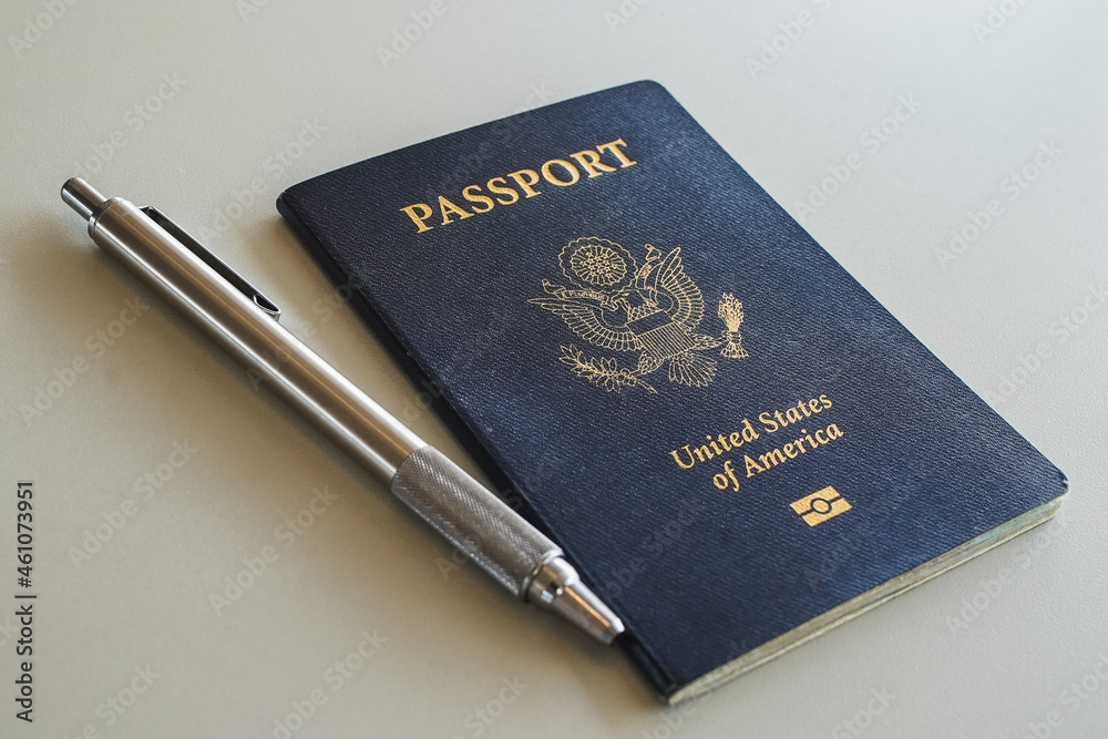 a blue passport with a pen on a desk a blue passport with a pen on a desk
