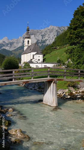 Pfarrkirche St. Sebastian in Ramsau mit der Ramsauer Ache und dem Ertlsteg im Vordergrund photo