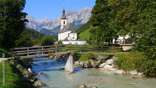 Pfarrkirche St. Sebastian in Ramsau mit der Ramsauer Ache und dem Ertlsteg im Vordergrund photo