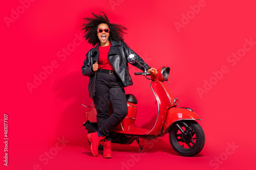 Full length photo of carefree excited lady good mood enjoy free time isolated on red color background