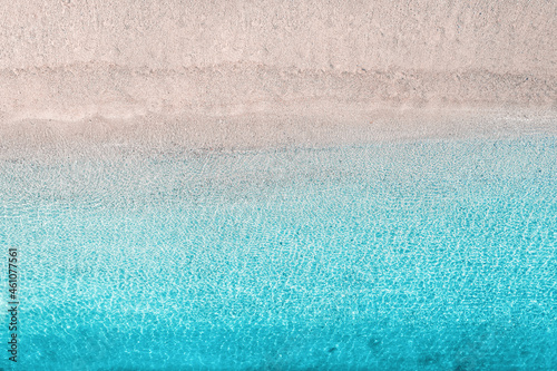 Blue, turquoise transparent water surface of ocean, sea, lagoon. Horizontal background. Top view of sand beach. Aerial, drone view