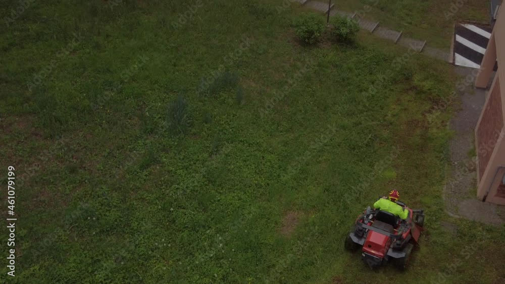 Lawnmower machine is cutting the grass in the garden. Lawnmower machine is cutting the grass in the garden.