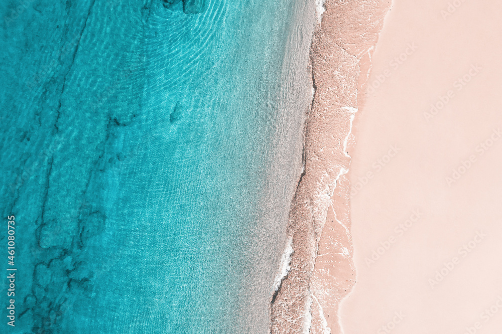 Fototapeta premium Relaxing aerial beach view with calm sea water and stone, slabs, lump, coral. Summer vacation. Blue ocean lagoon, sea shore, coastline. Drone, copter top view.