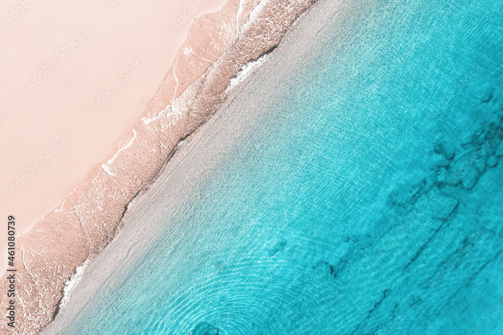 Relaxing aerial beach view with calm sea water and stone, slabs, lump, coral. Summer vacation. Blue ocean lagoon, sea shore, coastline. Drone, copter top view.