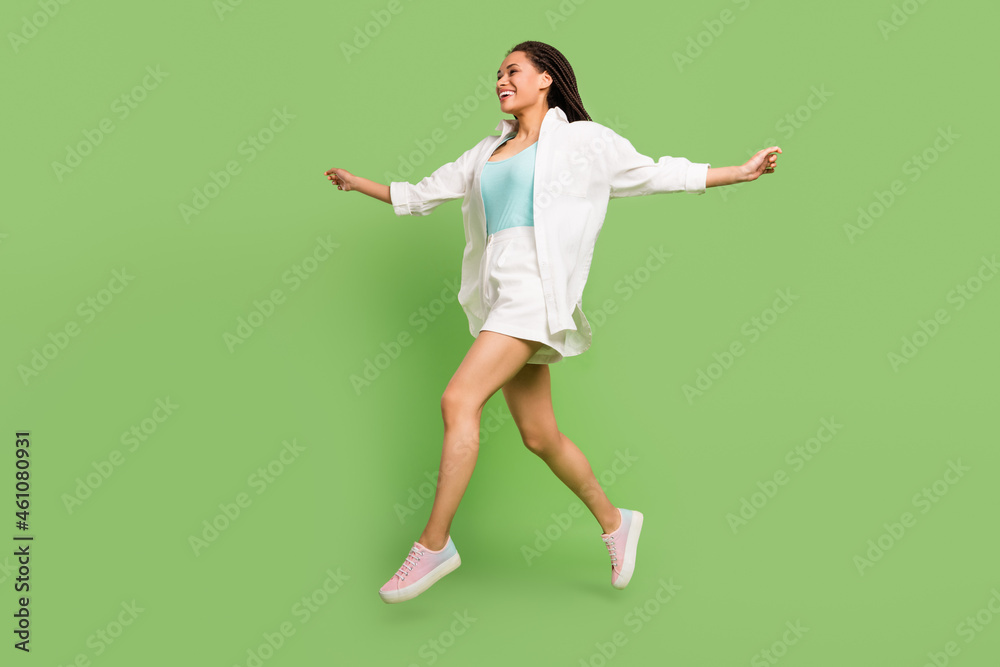 Full length body size photo woman jumping running smiling isolated pastel green color background Full length body size photo woman jumping running smiling isolated pastel green color background